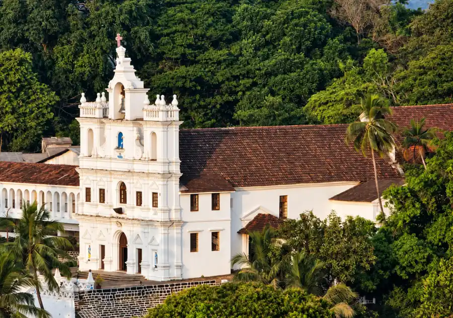 Historic white church surrounded by greenery in Panaji